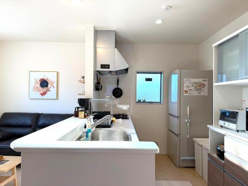 a kitchen with a sink and a refrigerator at The ITO 伊藤 in Abiko