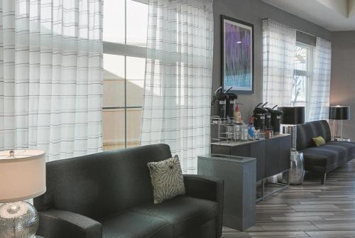 a waiting room with couches and a waiting area with aasteryasteryasteryastery at La Quinta by Wyndham Orlando Airport - On Property Food Trucks & Free Airport Shuttle! in Orlando