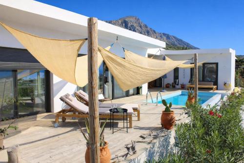 a patio with a hammock and a swimming pool at Villa Karma in Paleros
