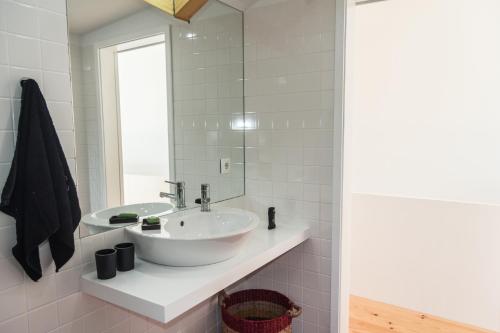 a bathroom with a white sink and a mirror at Apartamento City Center in Porto