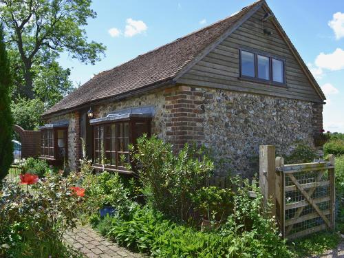 a stone house with a garden in front of it at The Stable in Hastingleigh