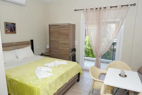 a bedroom with a bed and a table and a window at Ύδνα studios in Pefki