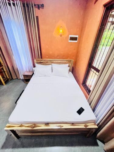 a bed in a room with two windows at Triple W in Watta