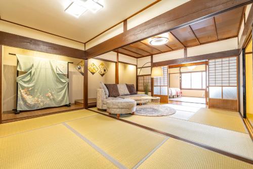 a living room with a couch and a window at Lax奈良 築65年和モダン古民家 一棟貸切 最大16名 専用ガレージ2台無料 自転車付き in Nara