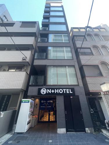 a tall building with a hotel sign in front of it at Nplus Tokyo Akihabara Premium in Tokyo