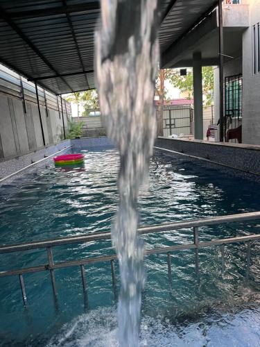 a water fountain in the middle of a swimming pool at Green Heaven Stay in Surat