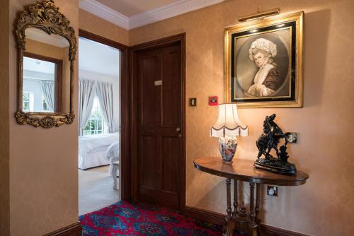 a hallway with a table with a lamp and a painting at Friars Quarter House in Ballinrobe