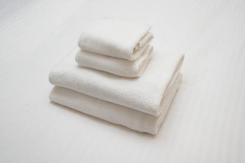 four white towels stacked on top of each other at Nplus Tokyo Akihabara Premium in Tokyo