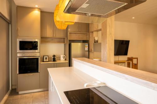 a kitchen with a white counter top in a room at ELYMUS - Spacious 3-Bedroom Apartment With Private Rooftop and Balcony - Near Le Morne And Lagoon in La Gaulette