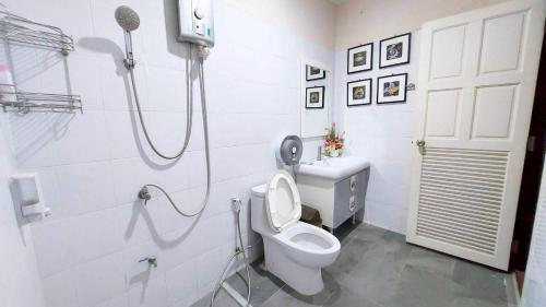 a white bathroom with a toilet and a shower at Baan Khun Pim Pool Villa in Ban Suan Maphrao