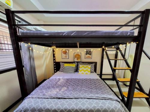 a bedroom with a bunk bed and a ladder at Baan Khun Pim Pool Villa in Ban Suan Maphrao