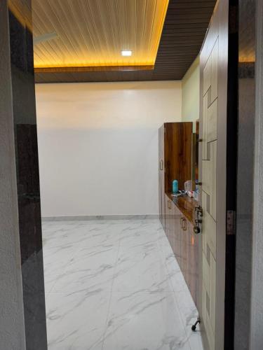 a hallway with a white marble floor in a room at Private Beach - Exotic Sea View Resort in Ganpatipule