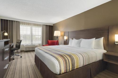a hotel room with a large bed and a desk at Country Inn & Suites by Radisson, Ankeny, IA in Ankeny