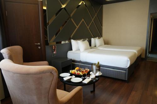 ein Hotelzimmer mit zwei Betten, einem Tisch und Stühlen in der Unterkunft Sultasa Hotel in Mersin