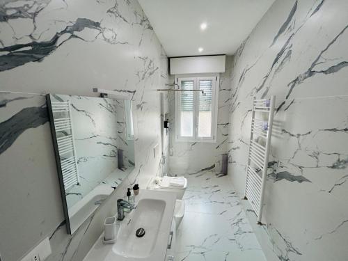 a white bathroom with a sink and a mirror at Terme Boutique House in Montegrotto Terme