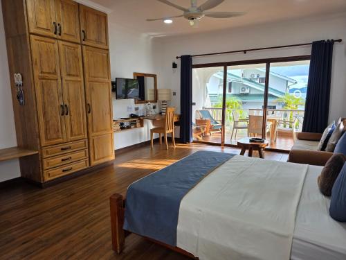 a bedroom with a bed and a living room at Drake Seaside Studio Apartments in Bel Ombre