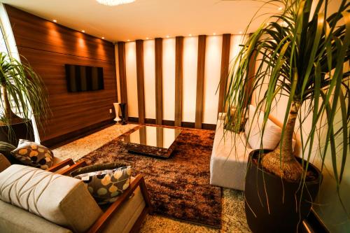uma sala de estar com um sofá e vasos de plantas em Hotel London Santarem em Santarém
