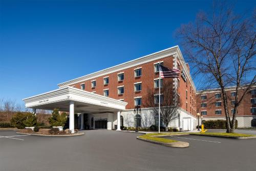 a building with an american flag in front of it at Hampton Inn & Suites By Hilton - Rockville Centre in Rockville Centre