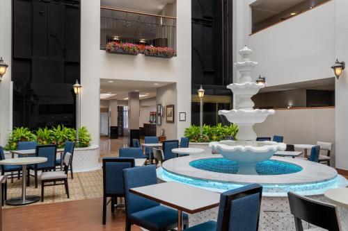 a lobby with a fountain and tables and chairs at Hampton Inn & Suites By Hilton - Rockville Centre in Rockville Centre