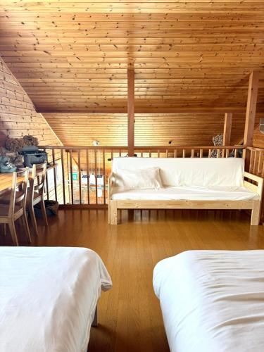 a bedroom with two beds and a wooden ceiling at chez Petit Lapinシェプチラパン in Karuizawa