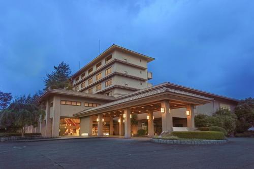 a building with a parking lot in front of it at Ooedo Onsen Monogatari Premium Seiunkaku in Awara