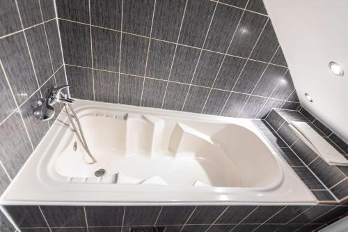 a bath tub with a faucet in a bathroom at Casa Valasoaia in Săcele