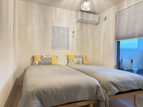 a bedroom with a large bed with a window at The ITO 伊藤 in Abiko