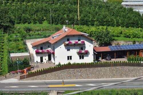 a white building with flowers in the window at Garni San Paolo in Appiano sulla Strada del Vino