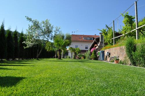 a large grassy yard with a house in the background at Garni San Paolo in Appiano sulla Strada del Vino