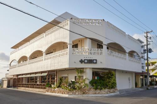 a white building on the corner of a street at HOTEL tuka miika in Ishigaki Island