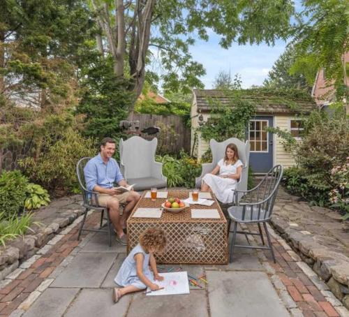 a family sitting on a patio with a little girl at Downtown Steps to Waterfront "The Garden" in Newburyport