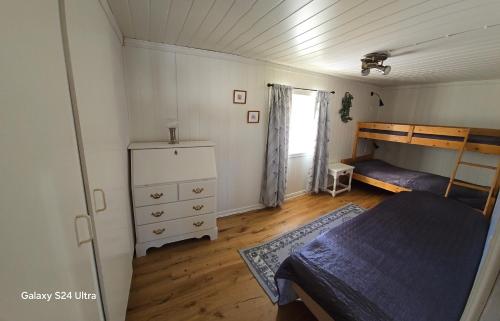 a bedroom with a bed and a dresser at Haga gård och Stall in Herräng