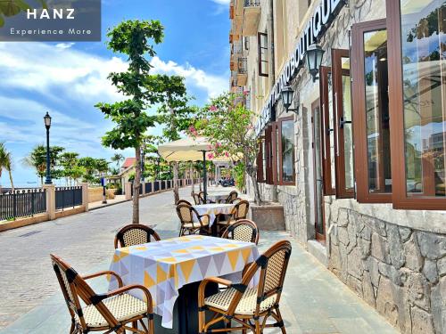 a table and chairs on a sidewalk in a street at HANZ Lagoon Sunset Hotel in Phú Quốc