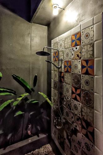 a bathroom with a shower with tiles on the wall at Sabi Studio in Timuran