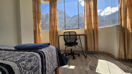 a bedroom with a chair in front of a window at Amazing views PISAQ in Pisac