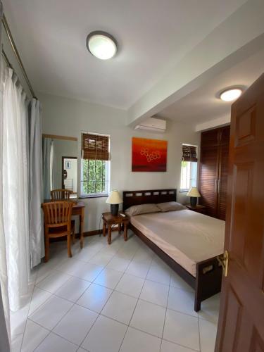 a bedroom with a bed and a table and chairs at Solmera Villa in Grand-Baie