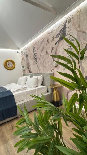 a living room with a bed and a plant at Hotel&SPA 5 HILLS DRAGASANI in Drăgăşani