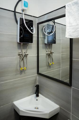 a bathroom with a sink and a mirror and a camera at Taurus B8-6 in Nairobi
