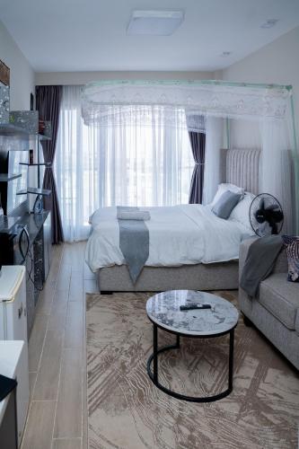 a bedroom with a bed and a couch and a table at Taurus B8-6 in Nairobi