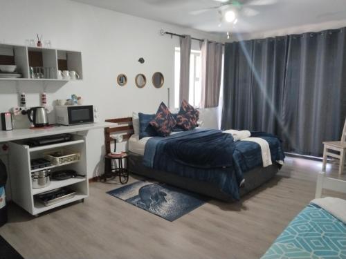 a bedroom with a bed and a desk in it at Ryans Surf Cabin in Jeffreys Bay