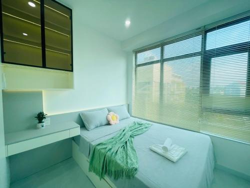 a bed in a room with a large window at TA Nhatrang Apartment in Nha Trang
