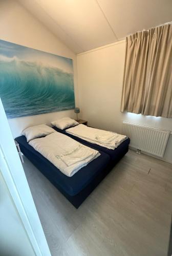 a bedroom with a bed and a painting on the wall at Slechtvalk 7 in Hulshorst