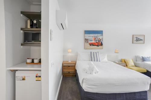 a small bedroom with a bed and a couch at Bay View - The Trio in Lorne
