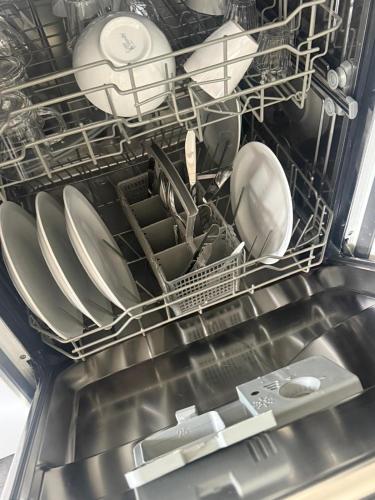 a dishwasher filled with plates and dishes in a kitchen at Slechtvalk 7 in Hulshorst