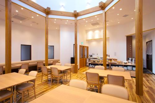a room filled with tables, chairs, and tables at Hotel Bliss Villa Hasami in Hasami