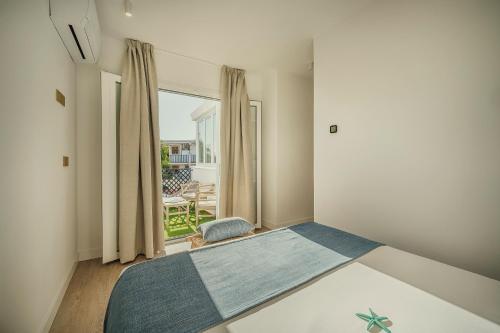 a bedroom with a bed and a window at Beneste Nerja Hostal in Nerja