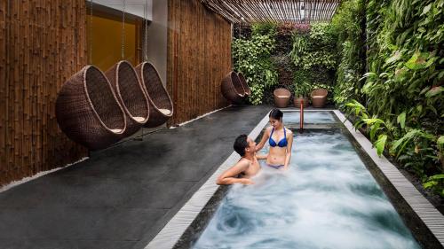 dos mujeres en una piscina en un edificio en Alba Spa Hotel en Hue