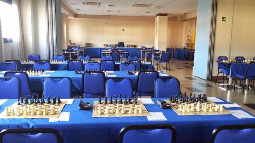 a room with blue tables and blue chairs with chess at Hotel Naval Sestao in Sestao