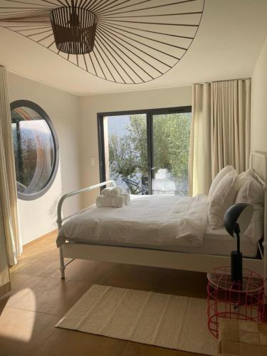 a bedroom with a large bed and a large window at luxe et sérénité in Lecci