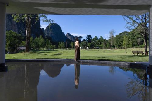 Eine Statue einer Frau, die neben einem Wasserbecken steht in der Unterkunft YINGMAN HOTEL in Yangshuo